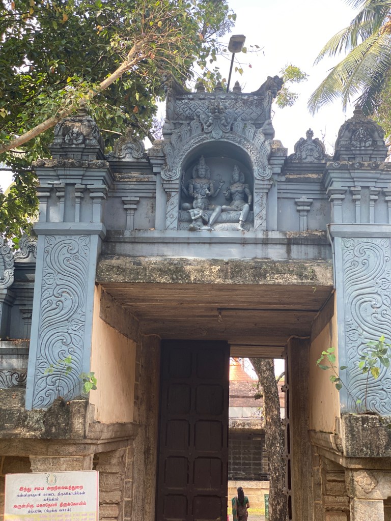 Stone entrance of Sree Adikesava Perumal Temple with detailed carvings, a sculpted deities panel above the doorway, and trees surrounding the structure
