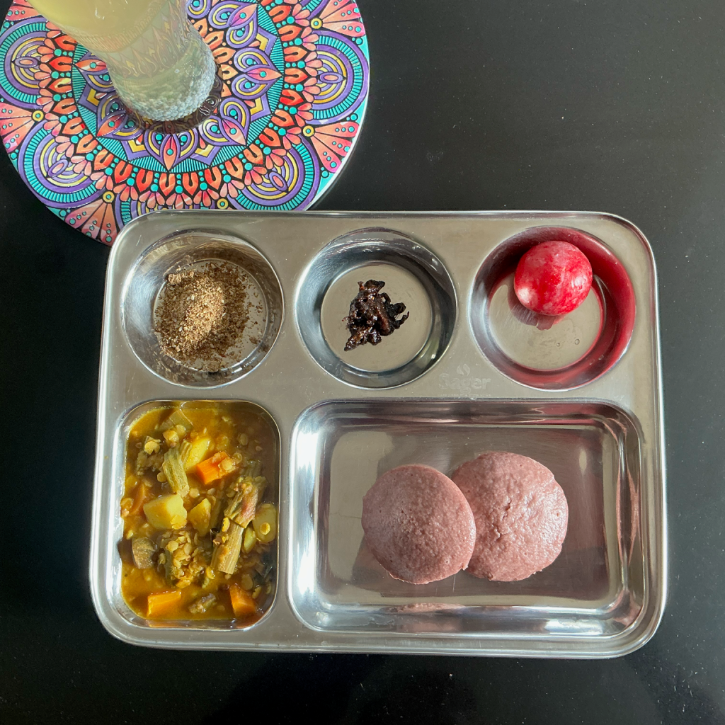 Nourishing meal with black rice idli, vegetable sambar and flax sesame chutney on a plate